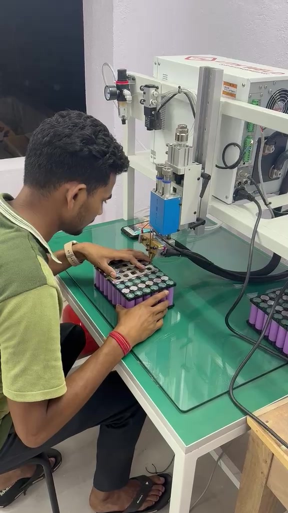GreenNext factory technician working on a cylindrical-cell battery pack at the assembly station